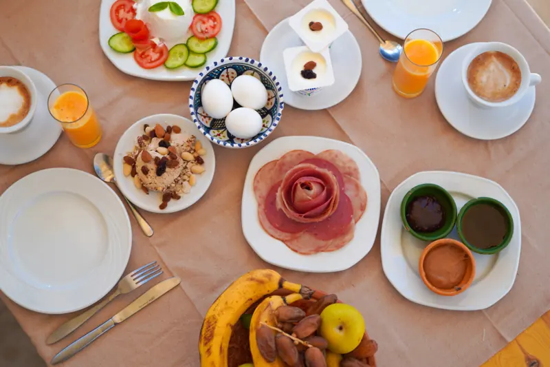 Le petit-déjeuner vu d'en haut : café, jus d'orange, œufs, fruits et dattes