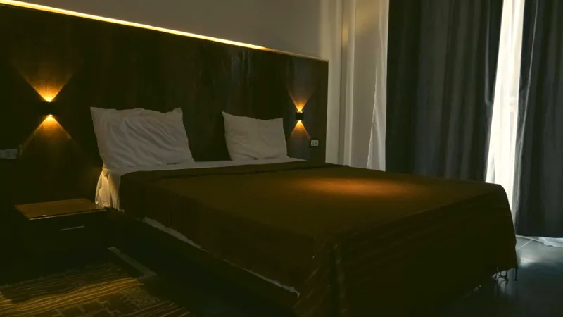 La tête de lit en bois de palmier éclairée le soir